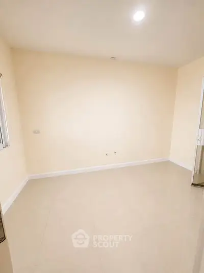 Spacious empty room with cream walls and glossy tiled floor, ideal for customization.