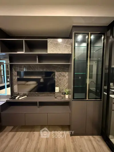 Modern living room with sleek TV unit and glass cabinet, perfect for stylish urban living.