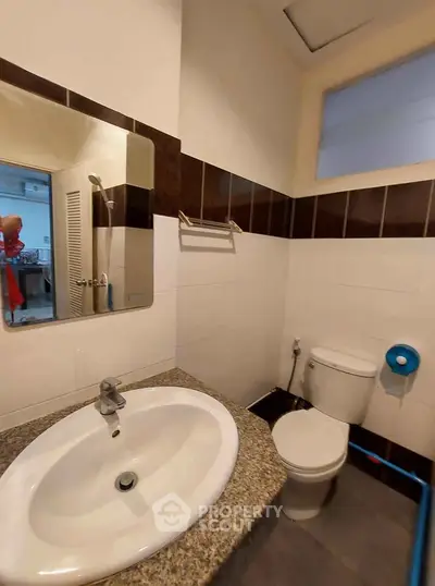 Compact bathroom with modern sink and toilet in a cozy apartment.