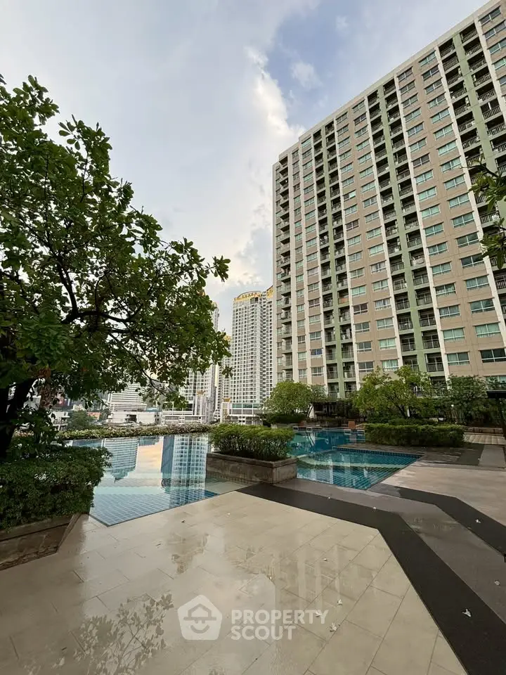 Luxurious high-rise building with stunning pool and city view, perfect for urban living.