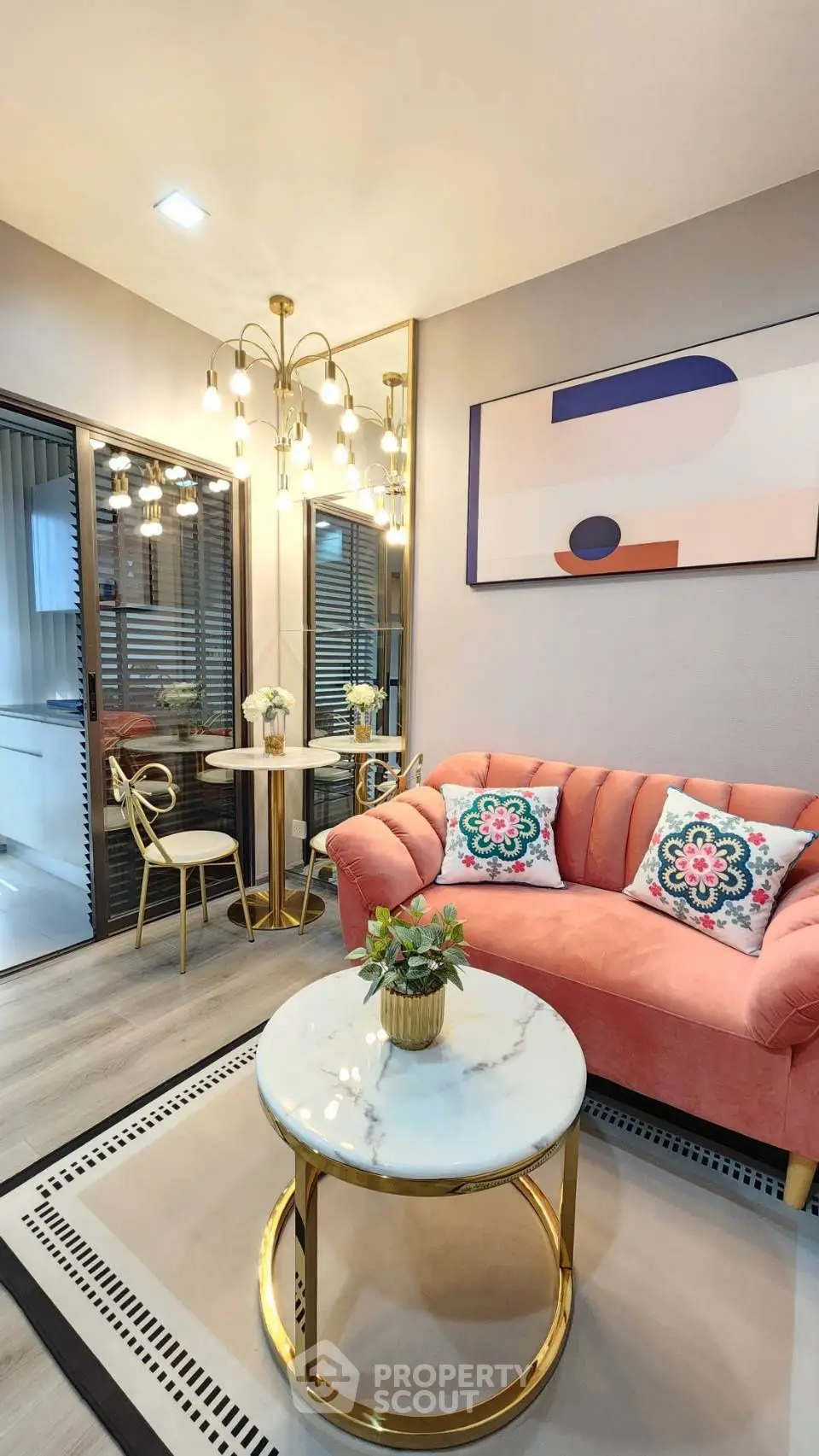 Stylish living room with modern decor, featuring a pink sofa, chic lighting, and elegant dining area.