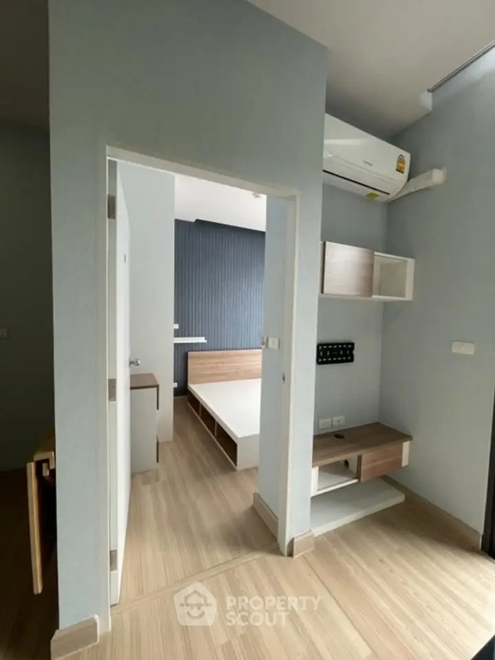 Modern bedroom with wooden flooring and built-in air conditioning unit.