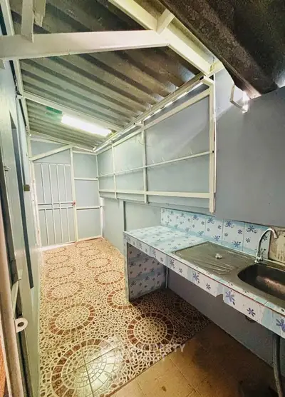 Charming rustic kitchen with tiled countertop and unique flooring, perfect for cozy home cooking.