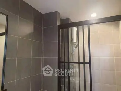 Modern bathroom with sleek tiled walls and glass shower enclosure