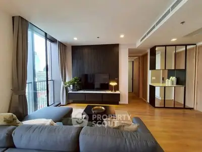 Modern living room with large windows and stylish decor in a high-rise apartment.