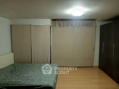 Spacious bedroom with large wardrobe and cozy lighting, perfect for relaxation.