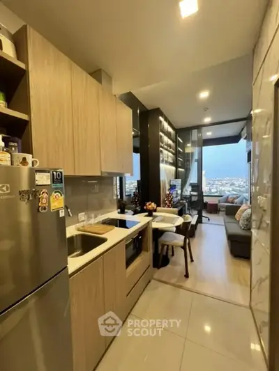 Modern open-layout kitchen with sleek appliances and city view from living area.