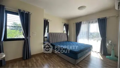 Spacious bedroom with large windows and stylish curtains