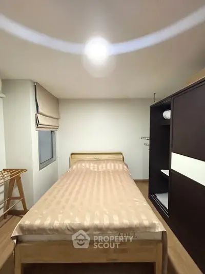 Cozy bedroom with single bed and wardrobe, perfect for minimalist living.