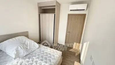 Modern minimalist bedroom with wooden flooring and built-in wardrobe