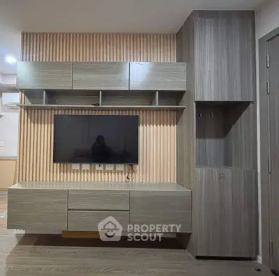 Modern living room with sleek wooden TV unit and ample storage space.