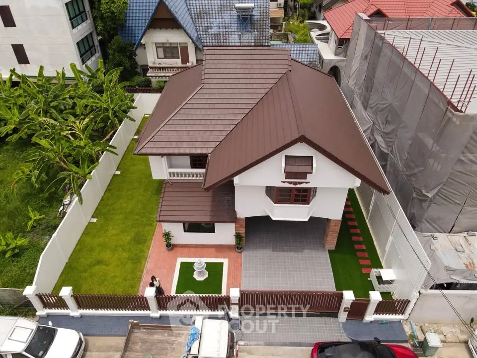 Charming suburban house with lush garden and modern roof design, perfect for family living.
