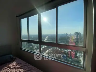 Stunning high-rise apartment with panoramic city view from large window, perfect for urban living.