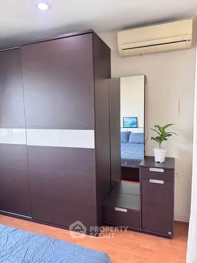 Modern bedroom with sleek wardrobe and air conditioning unit
