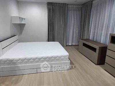 Spacious modern bedroom with minimalist design and ample natural light.