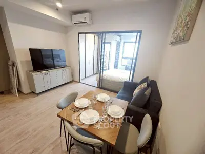 Modern open-plan living room with dining area and large TV, perfect for entertaining.