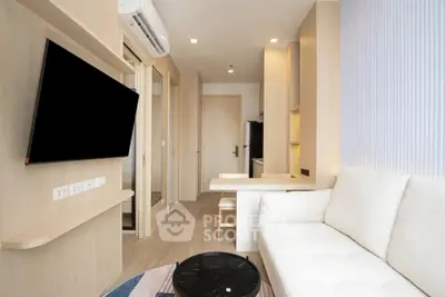 Modern living room with sleek design and wall-mounted TV in a cozy apartment.