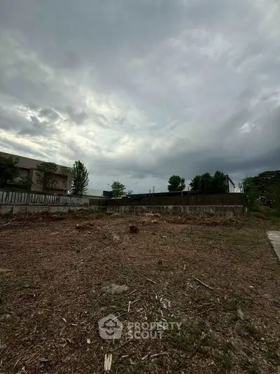 Spacious vacant land under cloudy sky, ideal for development opportunities.