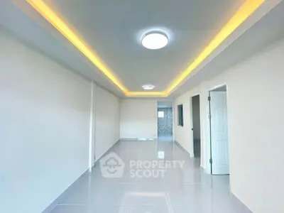 Spacious modern living room with sleek lighting and glossy tile flooring