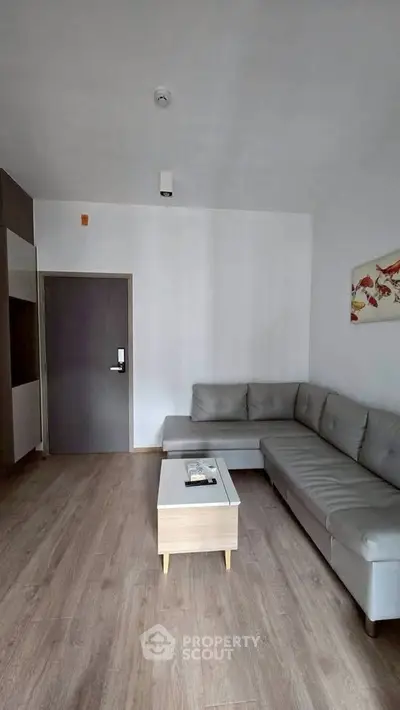 Modern living room with sleek gray sectional sofa and wooden coffee table
