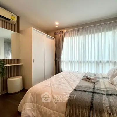 Cozy bedroom with large window, modern decor, and ample natural light.