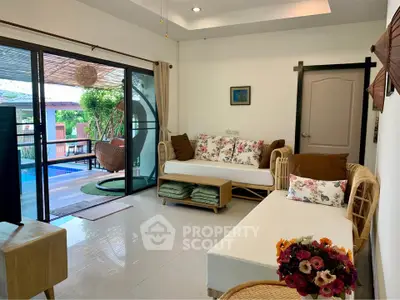 Charming living room with pool view and cozy seating area, perfect for relaxation and entertaining.