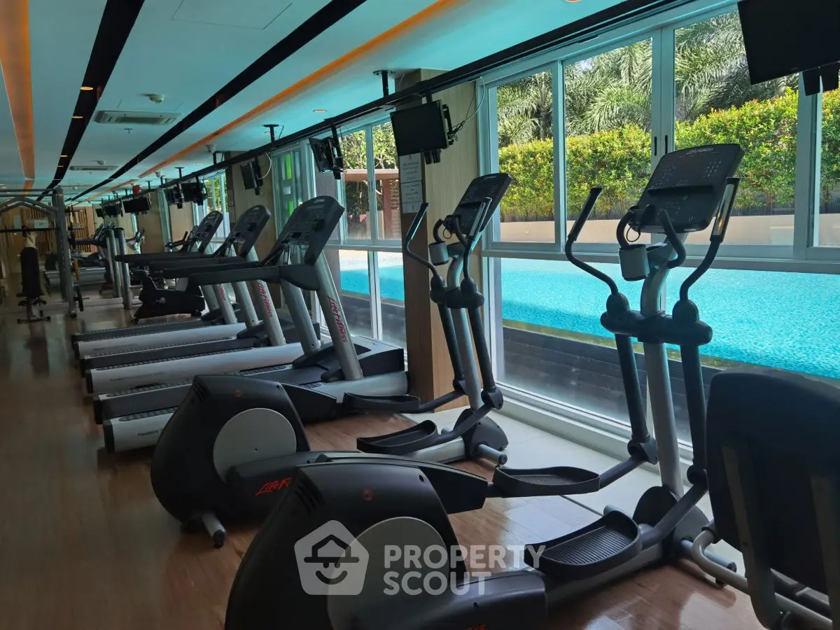 Luxurious gym with modern equipment and pool view in upscale property.