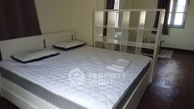 Spacious bedroom with modern decor and large bed in a cozy apartment.