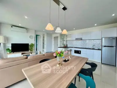 Modern open-plan living room and kitchen with stylish decor and ample natural light.