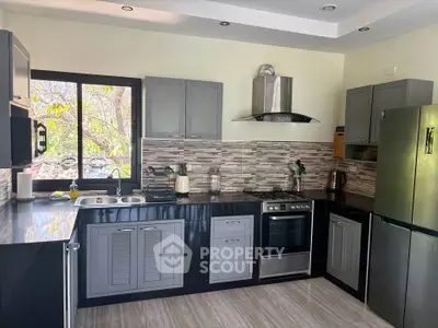 Modern kitchen with sleek cabinetry, stainless steel appliances, and a scenic window view.