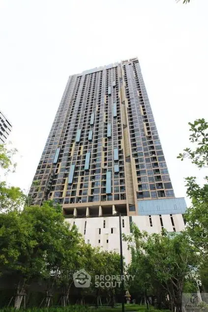 Stunning high-rise building with modern architecture and lush greenery in urban setting.