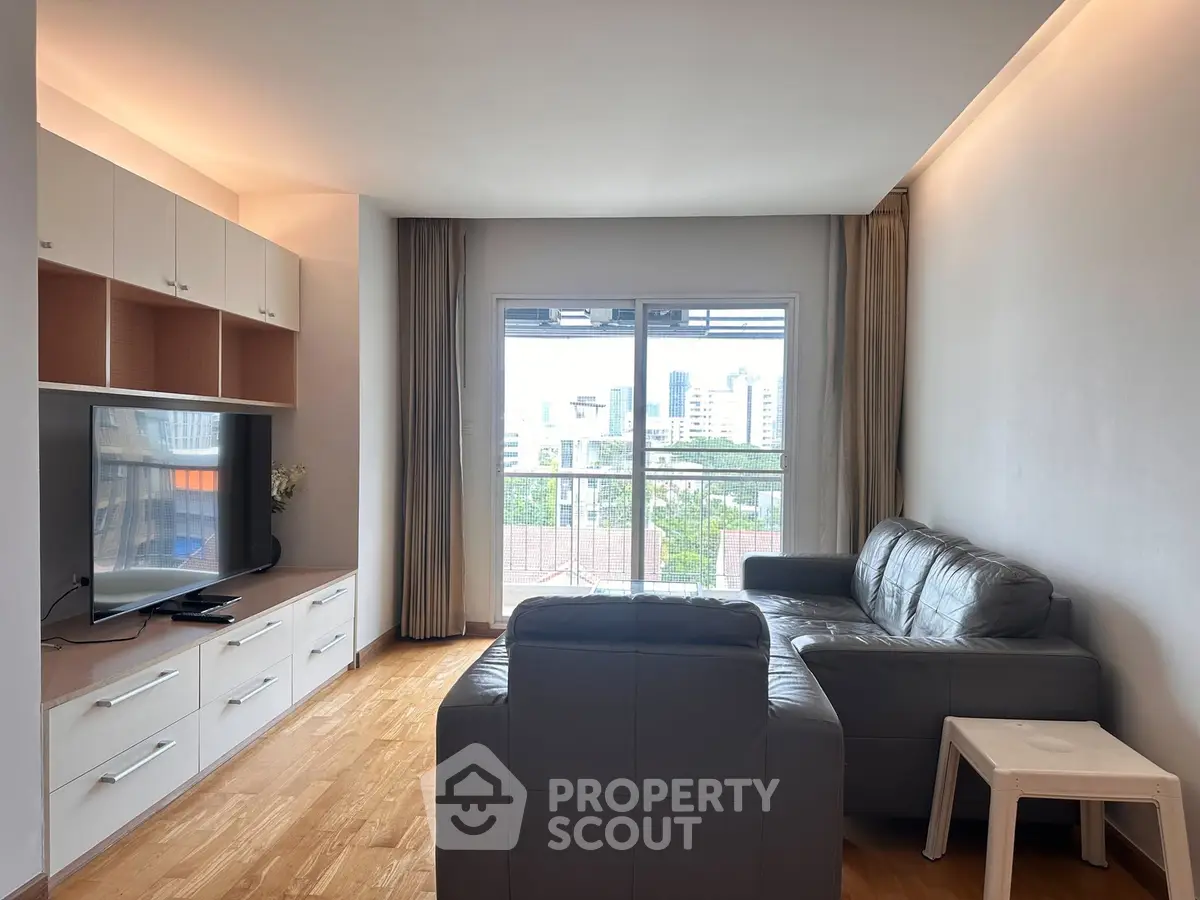 Spacious living room with modern furniture and city view, perfect for relaxation and entertainment.