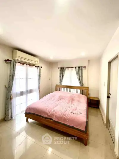 Bright and cozy bedroom with natural light and modern furnishings.