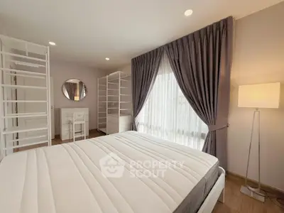 Spacious bedroom with elegant curtains and ample storage in modern apartment