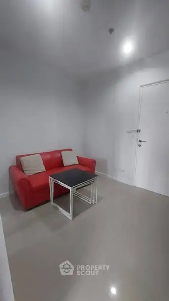 Modern minimalist living room with red sofa and sleek coffee table