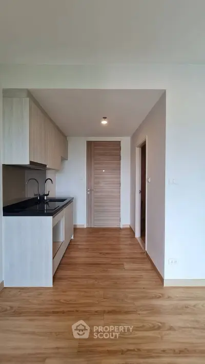 Modern kitchen with sleek cabinetry and wood flooring in a stylish apartment