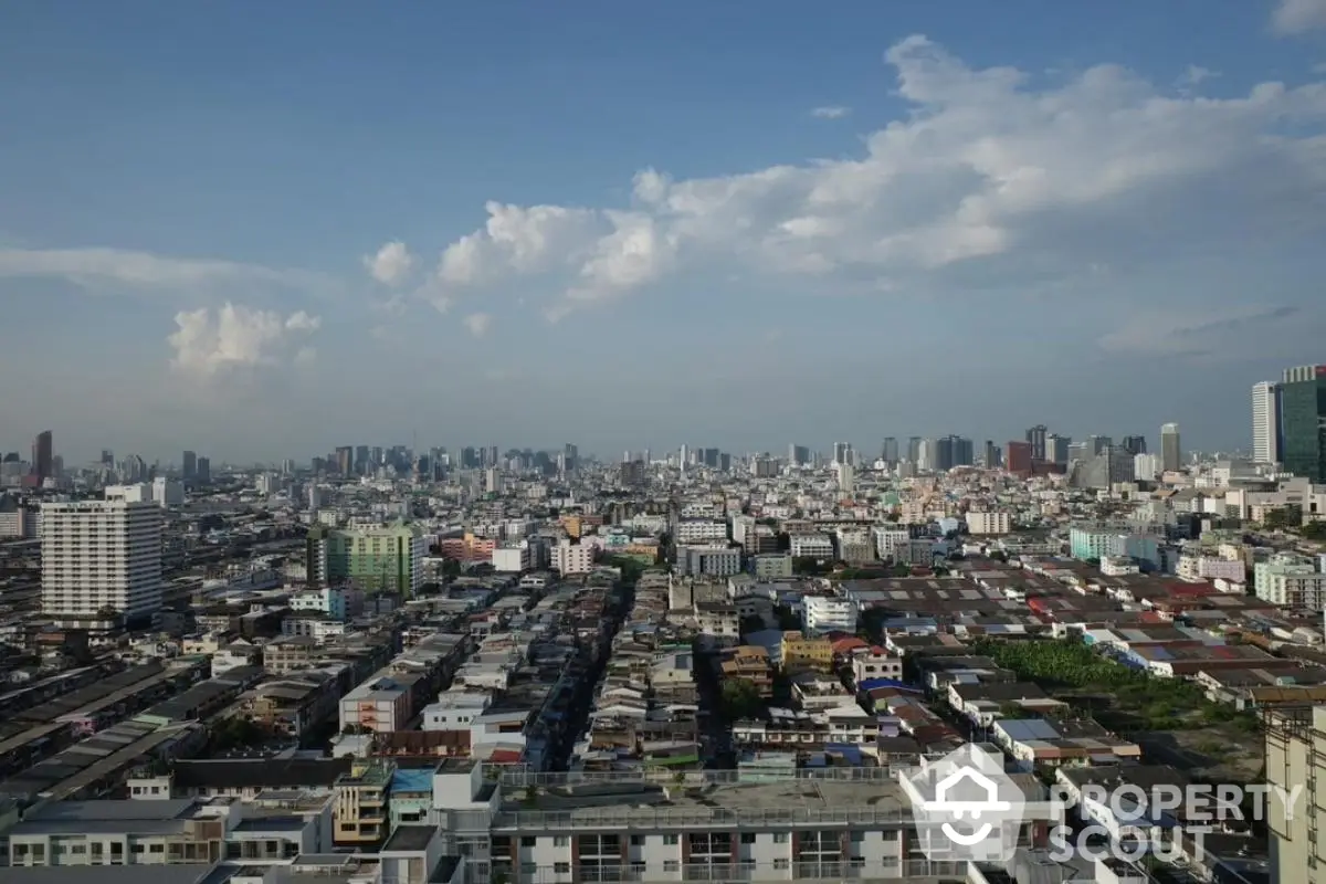 Stunning panoramic cityscape view showcasing urban skyline and residential buildings under a clear blue sky.