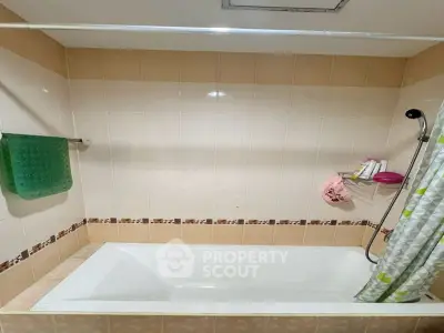 Cozy bathroom with bathtub and tiled walls, perfect for relaxation.
