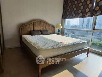 Spacious bedroom with large windows offering city views and natural light.