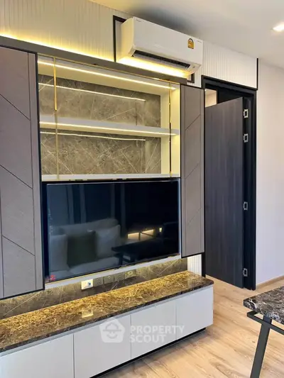 Modern living room with sleek TV unit and air conditioning in stylish apartment.