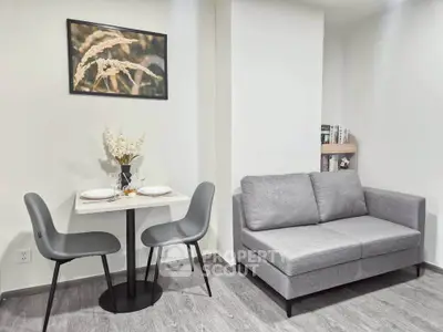 Modern living room with cozy gray sofa and dining area in stylish apartment.