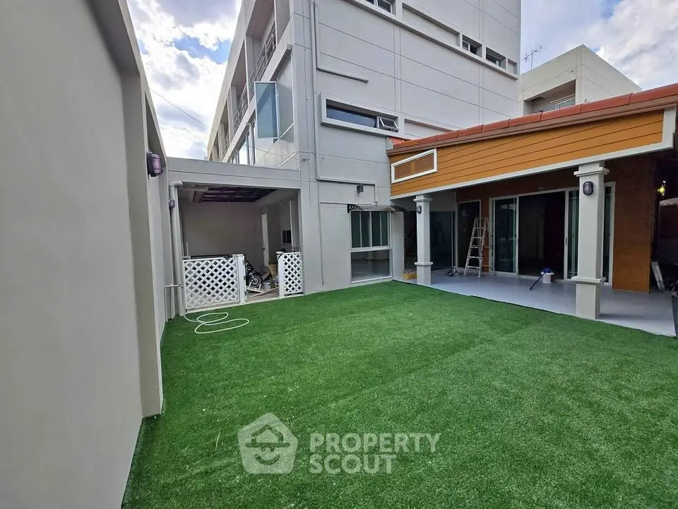 Spacious backyard with artificial grass and modern exterior design, perfect for outdoor activities.