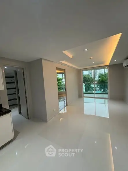 Spacious modern living room with large windows and sleek lighting.