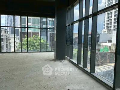 Spacious corner unit with floor-to-ceiling windows and city view, ideal for modern living or office space.