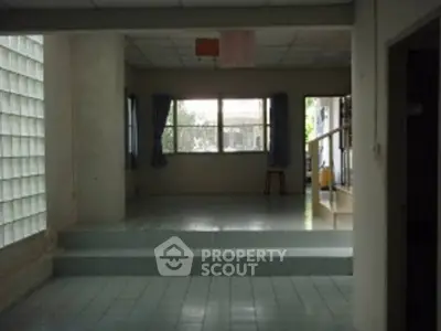Spacious interior with elevated tiled flooring and large windows for natural light.