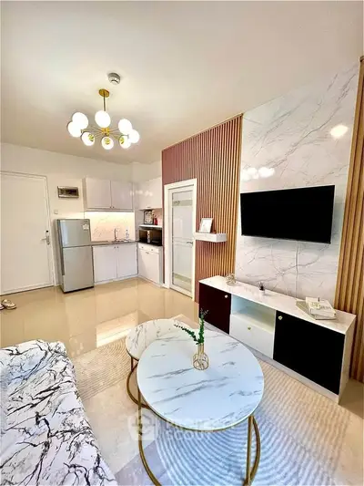 Modern living room with stylish decor and open kitchen layout, featuring marble accents and elegant lighting.