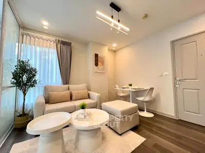 Modern living room with stylish furniture and dining area, featuring elegant lighting and cozy ambiance.