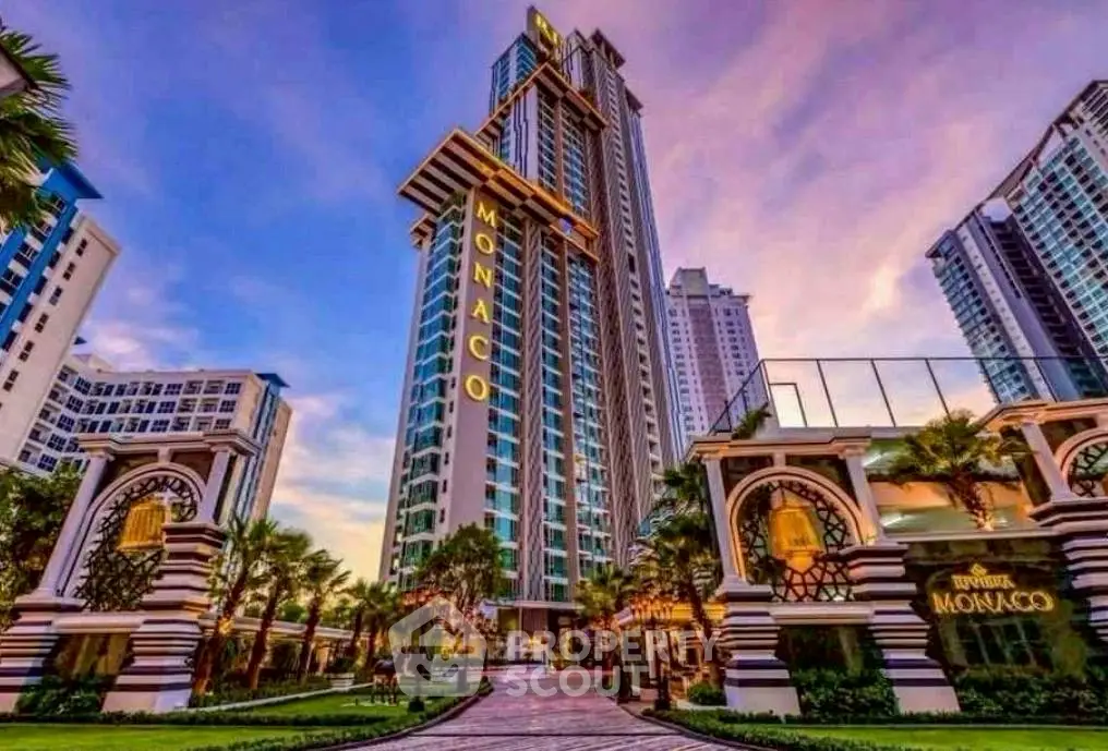 Stunning high-rise building with luxurious entrance and beautiful sunset backdrop.