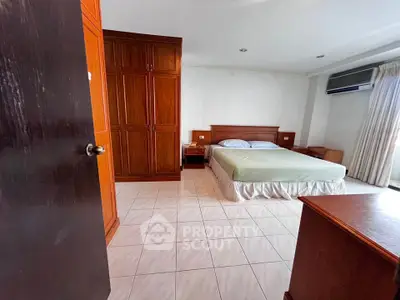Spacious bedroom with wooden furniture and air conditioning, perfect for comfort and relaxation.