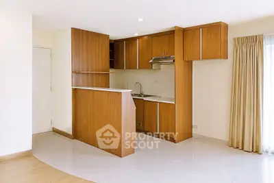 Modern kitchen with wooden cabinets and open layout in a bright apartment.